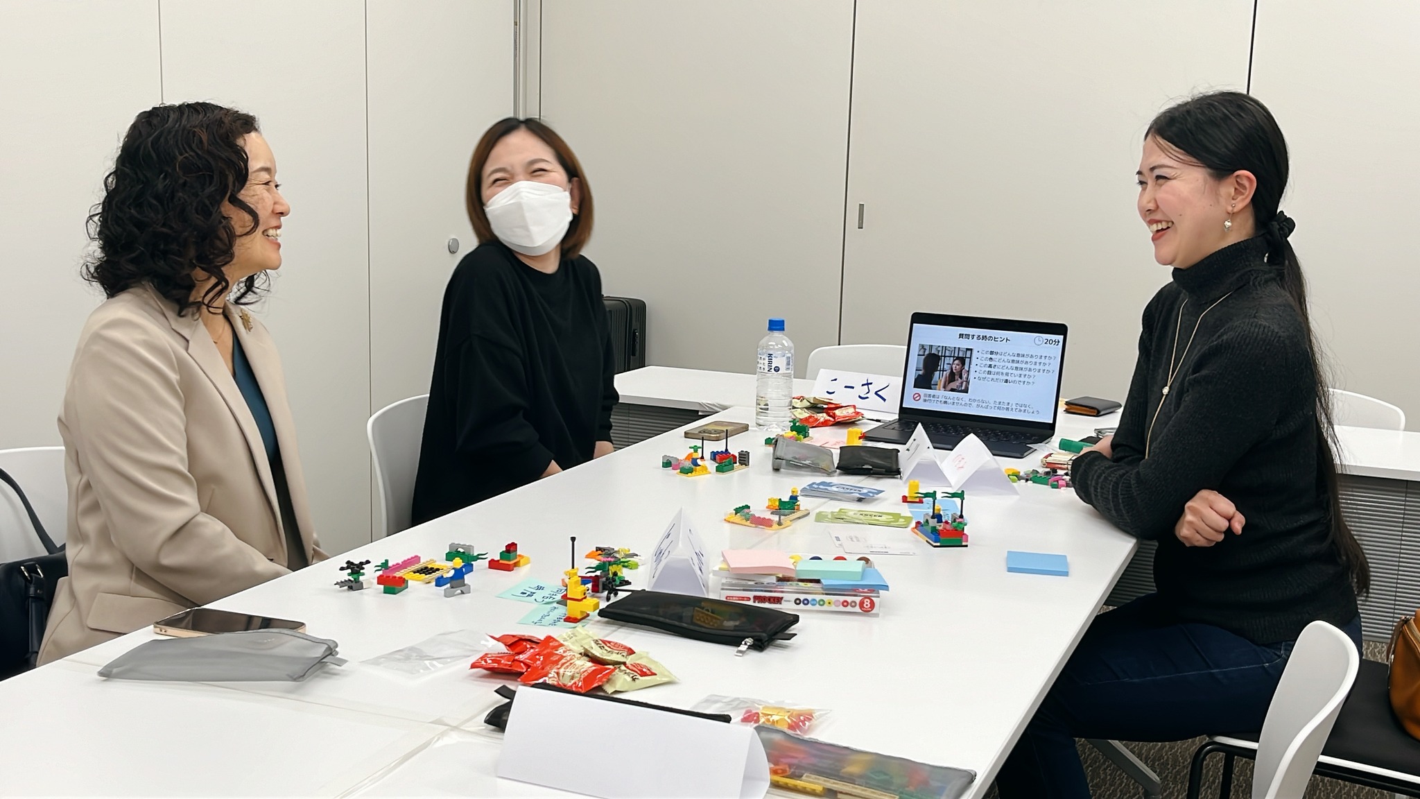 ワークショップでの対話風景。3名の参加者が作品を囲みながら、自身の働き方や価値観について語り合っている。