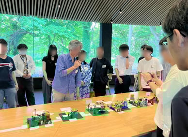 発表の様子。参加者が前に立ち、自分たちのLEGO®モデルを紹介しながらまちづくりへの想いを語っている。