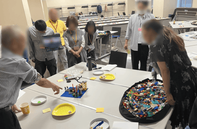 参加者が自作したLEGOモデルを囲み、構造や背景について対話している様子
